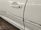 a close up of a white car with a broken door handle