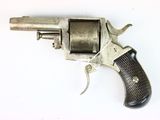 an old silver revolver with a wooden handle on a white surface
