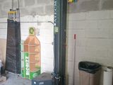 an image of a garage with a fork lift in the middle of the room