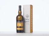 a bottle of whisky sitting next to a box on a table