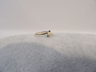 gros plan d'une bague en or sur une surface blanche