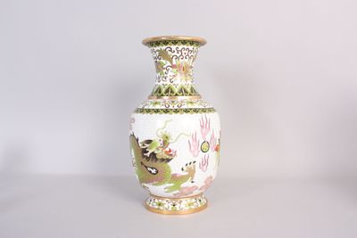 un vase blanc orné d'un motif vert et jaune