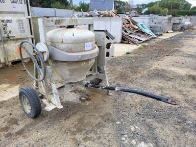a cement mixer that is sitting in the dirt