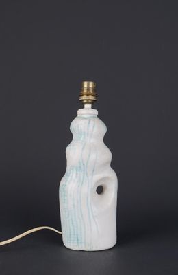 a white and blue ceramic lamp with a small light bulb on top of it