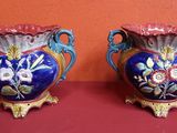 deux vases posés sur une table rouge