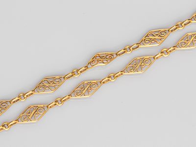 a close up of a pair of gold bracelets on a white surface