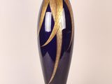 a blue vase with a gold leaf design on it