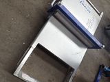 a machine that is sitting on the ground next to a piece of metal