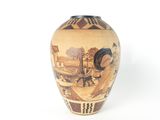 a vase with a painting on it on a white surface