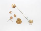 an image of a collection of gold jewelry on a white surface