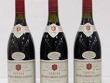 three bottles of wine are lined up on a white surface