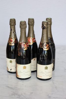 four bottles of wine are lined up on a marble table