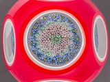 un vase rouge orné d'un motif bleu et blanc