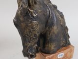 a statue of a horse that is sitting on a wooden block