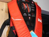 un gilet de sauvetage rouge accroché au mur à côté d'un sac à dos