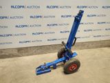 the blue hand truck is parked in front of a wall