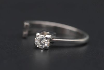 gros plan d'une bague en diamant sur une surface noire