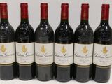 six bottles of red wine lined up in a row on a table