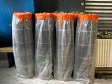 four bags of silver and orange plastic sitting on a bench