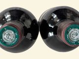 two bottles of wine sitting next to each other on a table