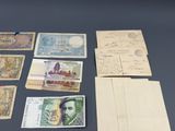 quelques vieux billets de banque posés sur une table, à côté d'une paire de ciseaux