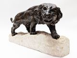 bronze statue of a dog on a rock on a white background
