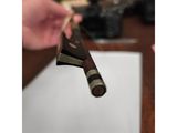 a person holding a knife in their hand over a piece of paper