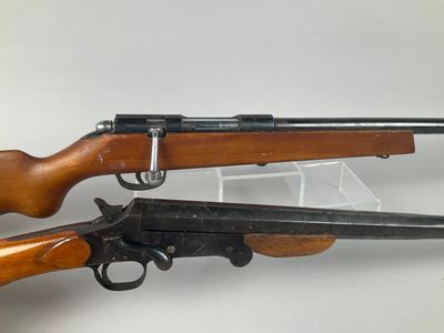 two guns are sitting side by side on a white surface