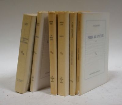 plusieurs livres sont empilés sur une surface blanche