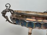 a silver bowl with a handle on a stand