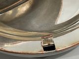 a silver plate with a silver lid on a white table