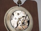 a close up of a clock on a wooden stand