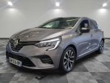 une voiture grise est garée dans une grande pièce au sol en damier
