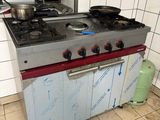 une cuisine avec une cuisinière et une casserole posée sur le plan de travail