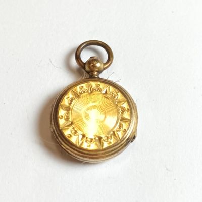 un petit cadenas en or sur lequel est gravée l'image d'une femme