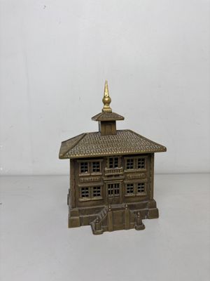 un petit bâtiment en bois au toit doré