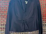 a black jacket hanging on a wall next to a red wall