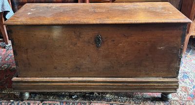 an old wooden chest sitting on top of a rug in a room