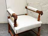 une chaise blanche ornée d'une tête de lion