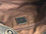 the inside of a brown and black bag with a brown leather handle