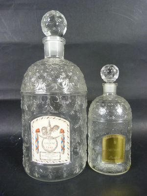 deux bouteilles en verre transparent posées l'une à côté de l'autre sur une surface noire