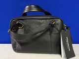 a black purse with a tag on it sitting on a table