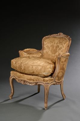un fauteuil rembourré dont l'assise est recouverte d'un tissu doré