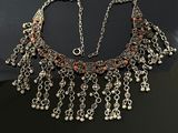 a close up of a necklace on a table with a black background