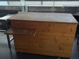a wooden table with a drawer on it in front of a window