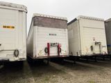trois semi-remorques garées côte à côte sur un parking
