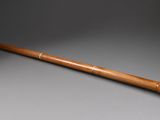 une vieille batte de baseball avec un manche en bois, posée sur une table