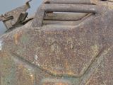 a rusty gas can with a bird on top of it