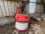 une machine rouge et blanche qui se trouve dans une grange