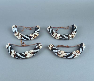 trois barrettes ornées de perles noires et blanches posées sur un fond gris